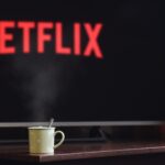 Netflix loading screen on television with a cup of coffee in front.